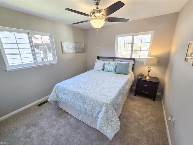 carpeted bedroom with ceiling fan and multiple windows