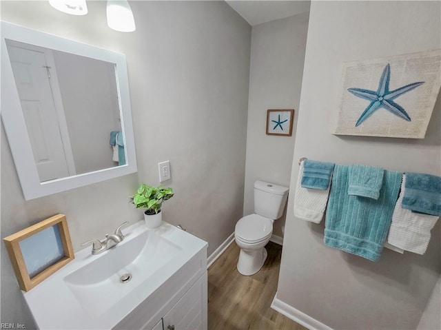 bathroom with vanity, toilet, and wood-type flooring