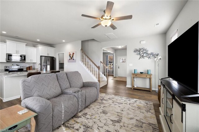 living room with dark hardwood / wood-style floors and ceiling fan