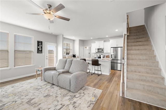 living room featuring ceiling fan and light hardwood / wood-style flooring