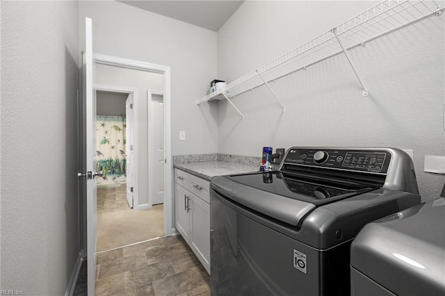 washroom with washer / dryer and cabinets