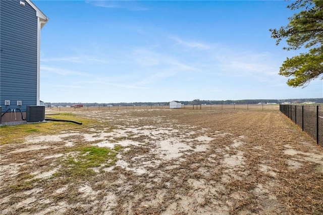 view of yard with central AC and a rural view