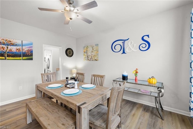 dining space with wood-type flooring and ceiling fan