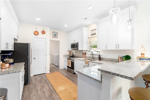 kitchen with a kitchen bar, white cabinetry, decorative light fixtures, kitchen peninsula, and stainless steel appliances