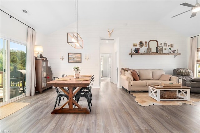 dining area with hardwood / wood-style floors, vaulted ceiling, and ceiling fan