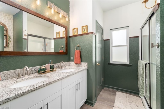 bathroom featuring hardwood / wood-style flooring, vanity, and an enclosed shower