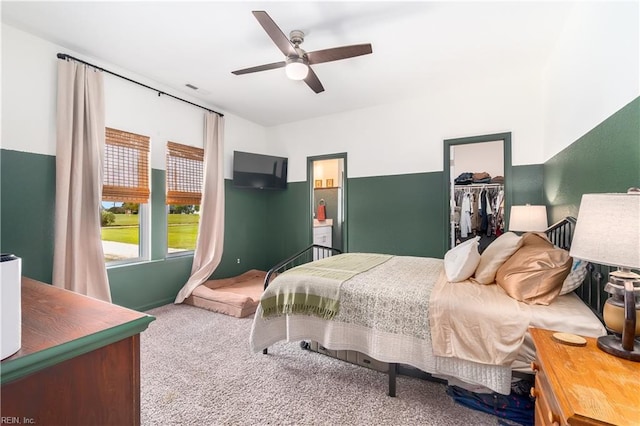 bedroom featuring a spacious closet, carpet flooring, ceiling fan, and a closet