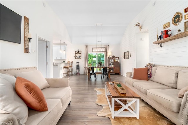 living room with hardwood / wood-style floors and high vaulted ceiling