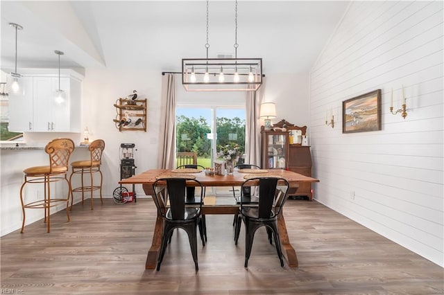 dining space with dark hardwood / wood-style flooring and vaulted ceiling