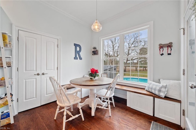 dining space with dark wood-type flooring and ornamental molding