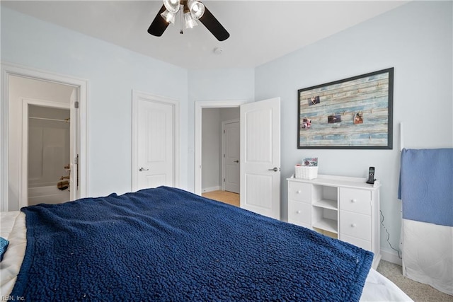 bedroom with light carpet, connected bathroom, and ceiling fan