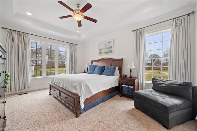 bedroom with ceiling fan, ornamental molding, a raised ceiling, and carpet floors