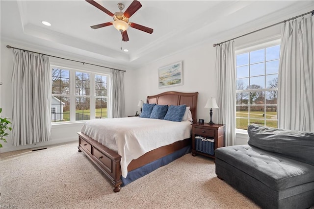 carpeted bedroom featuring crown molding, a tray ceiling, and ceiling fan