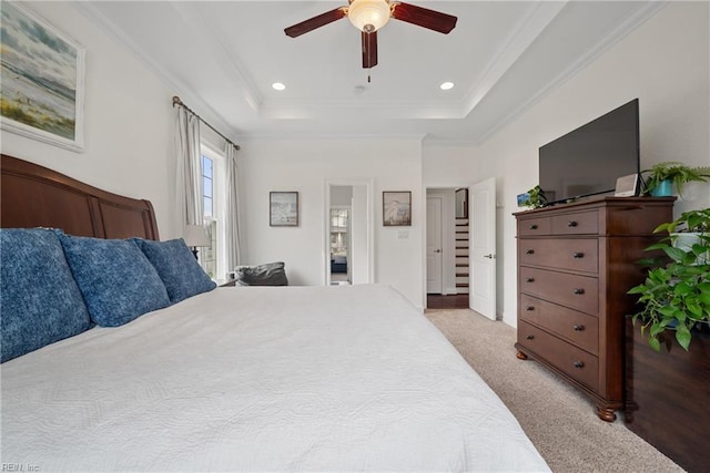 carpeted bedroom featuring ornamental molding, ceiling fan, and a tray ceiling