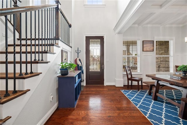 foyer entrance featuring dark wood-type flooring and a towering ceiling