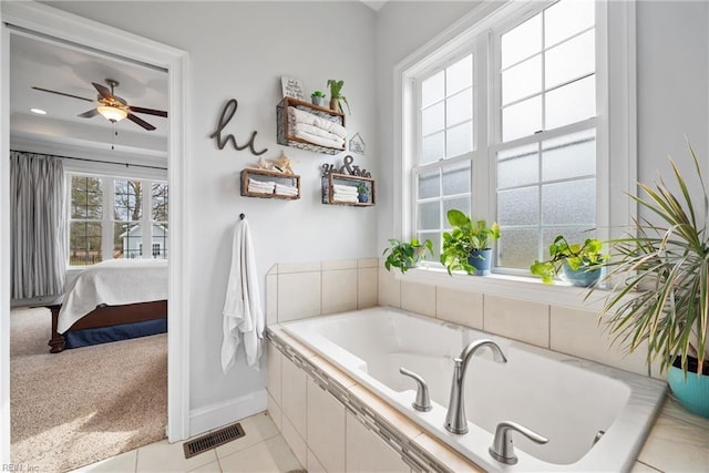 bathroom featuring ceiling fan, tile patterned flooring, and tiled tub