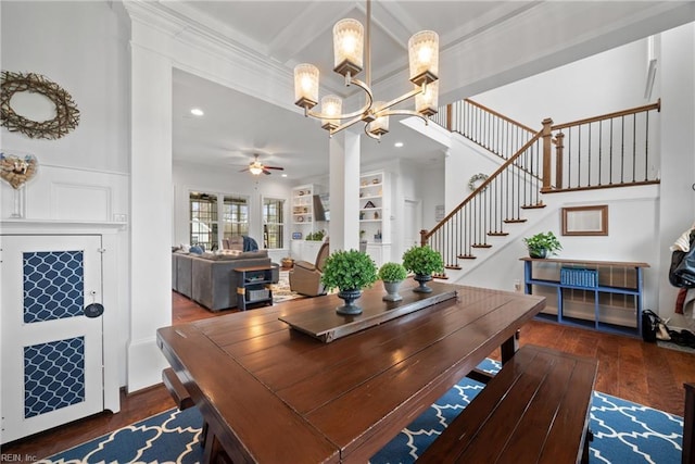 dining space with ornamental molding, dark hardwood / wood-style floors, ceiling fan with notable chandelier, and built in features