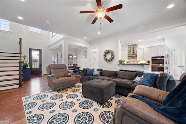 living room featuring ceiling fan, ornamental molding, and wood-type flooring