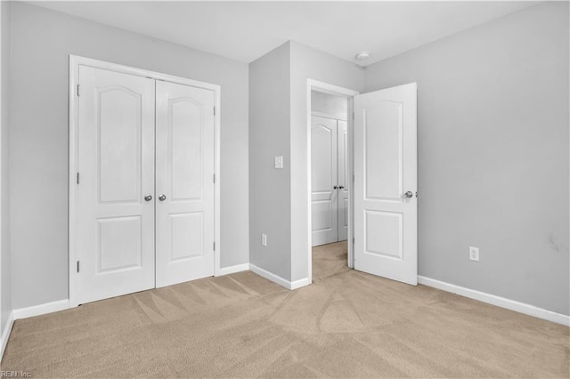 unfurnished bedroom with light carpet and a closet