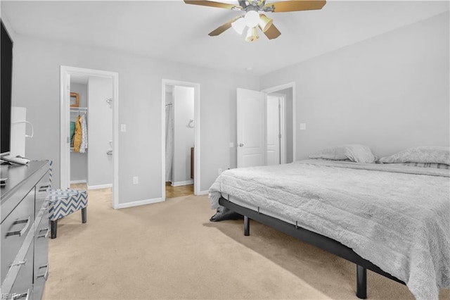 carpeted bedroom with a spacious closet, ceiling fan, and a closet