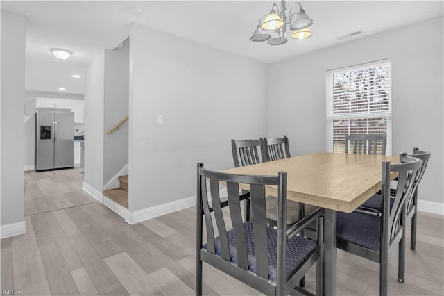 dining space with an inviting chandelier and light wood-type flooring