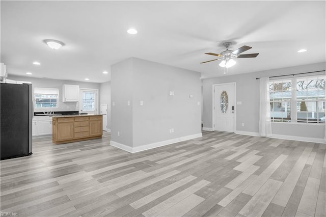 unfurnished living room featuring ceiling fan and light hardwood / wood-style floors