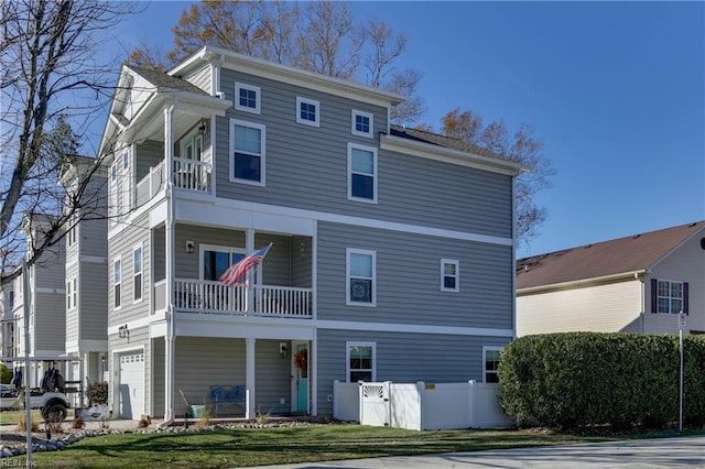 rear view of property with an attached garage and a balcony