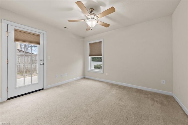 empty room with a ceiling fan, light carpet, visible vents, and baseboards