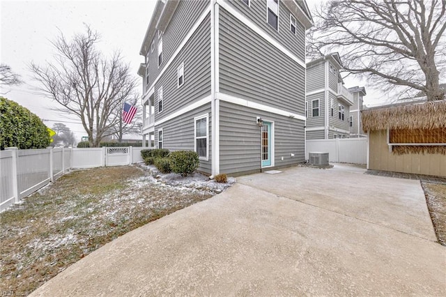 view of side of property featuring central AC unit, a patio area, and a fenced backyard