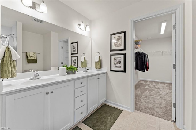 129 Getty Rd, Suffolk, VA 23434 - bathroom with double vanity, a spacious closet, tile patterned flooring, and baseboards