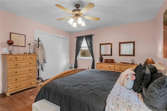 bedroom with ceiling fan, light wood-type flooring, and a closet