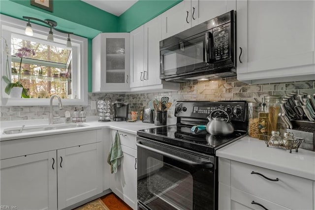 kitchen with sink, decorative backsplash, black appliances, and white cabinets