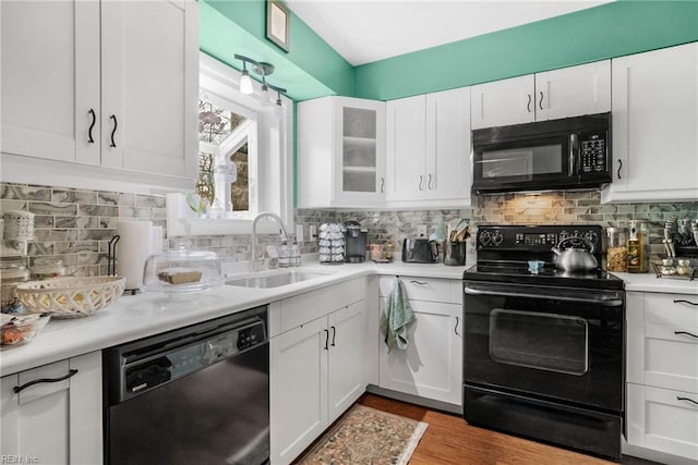 kitchen with sink, white cabinets, and black appliances