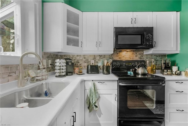 kitchen featuring white cabinetry, sink, backsplash, and black appliances