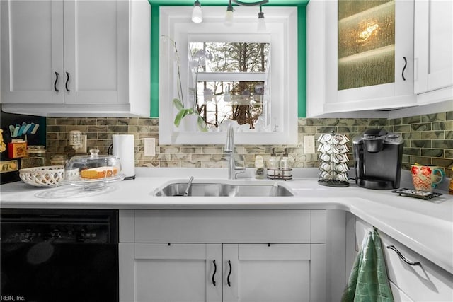 kitchen with tasteful backsplash, black dishwasher, sink, and white cabinets