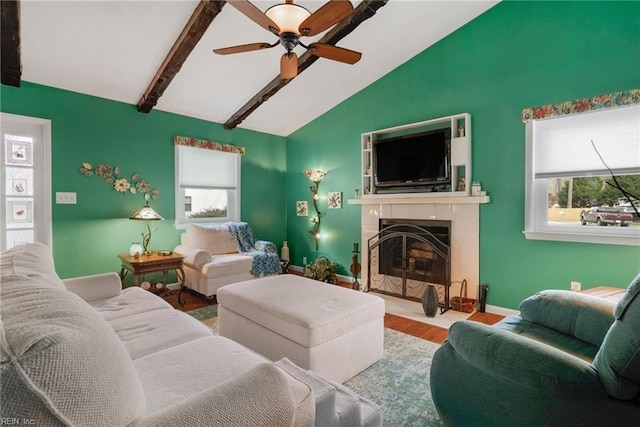 living room featuring hardwood / wood-style flooring, a wealth of natural light, lofted ceiling with beams, and a high end fireplace