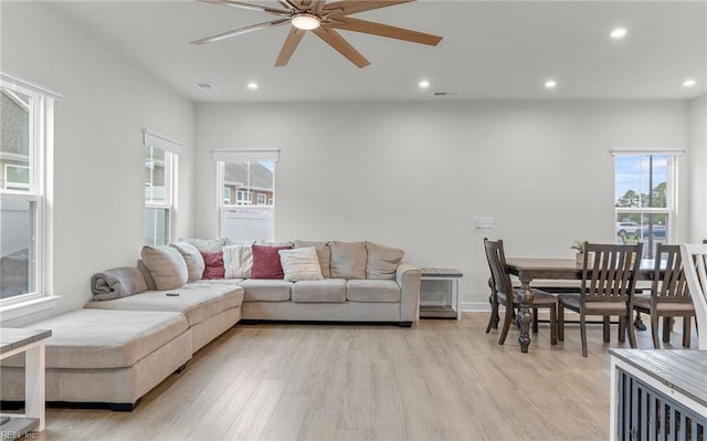 living room featuring ceiling fan and light hardwood / wood-style floors