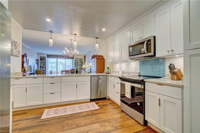 kitchen with stainless steel appliances, white cabinetry, hanging light fixtures, and kitchen peninsula