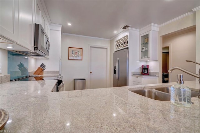 kitchen featuring stainless steel appliances, white cabinetry, sink, and light stone counters