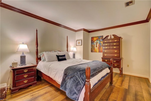 bedroom with crown molding and hardwood / wood-style floors