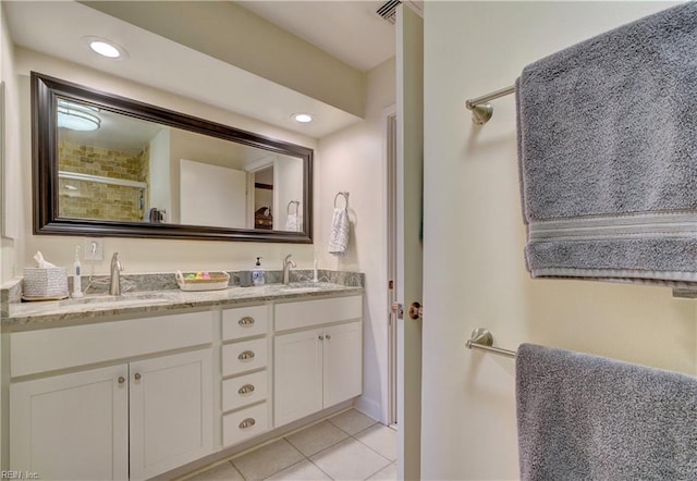 bathroom with walk in shower, vanity, and tile patterned flooring