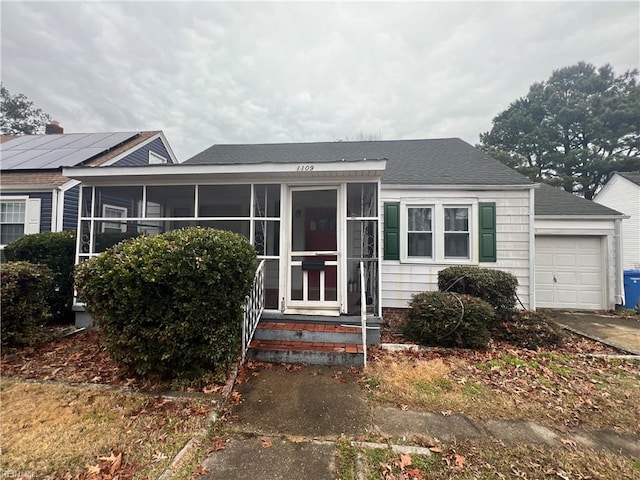 view of front of home with a garage and a sunroom