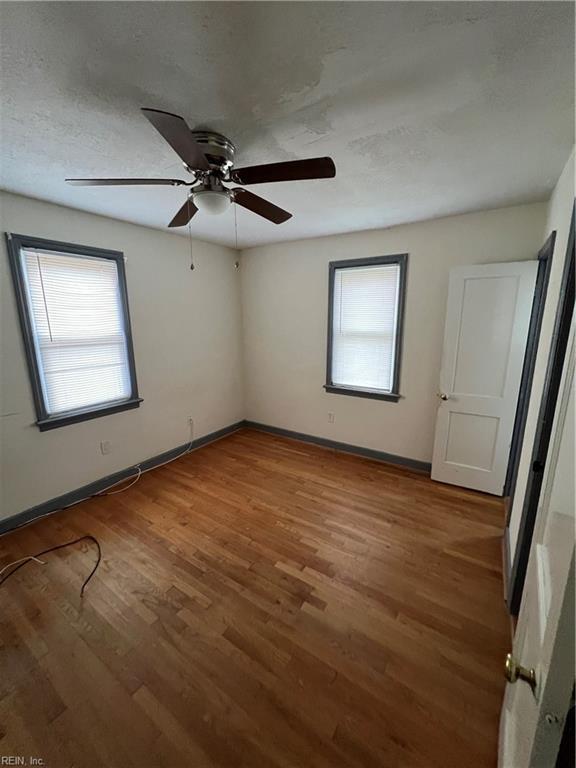 spare room with hardwood / wood-style flooring, plenty of natural light, and a textured ceiling