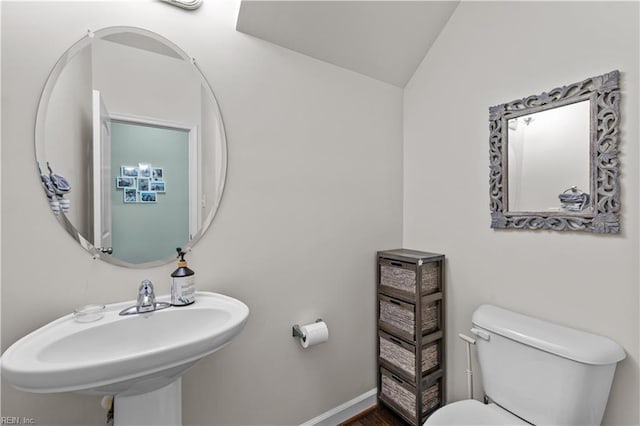 bathroom with lofted ceiling, sink, and toilet