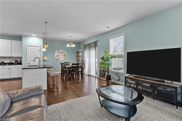 living room with dark hardwood / wood-style flooring and sink