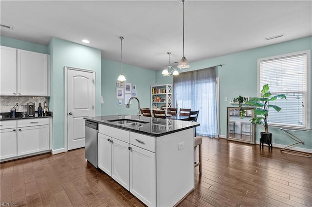 kitchen featuring a kitchen island with sink, sink, white cabinetry, and stainless steel dishwasher