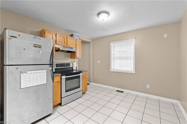 kitchen with light brown cabinetry, light tile patterned floors, and appliances with stainless steel finishes