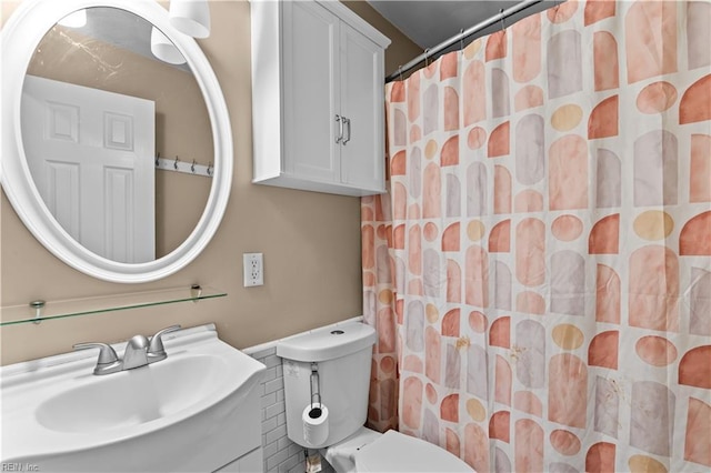 bathroom featuring vanity, curtained shower, and toilet