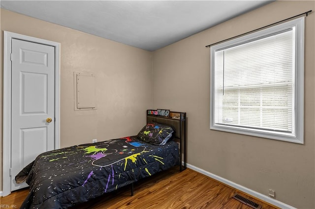 bedroom with hardwood / wood-style flooring and electric panel