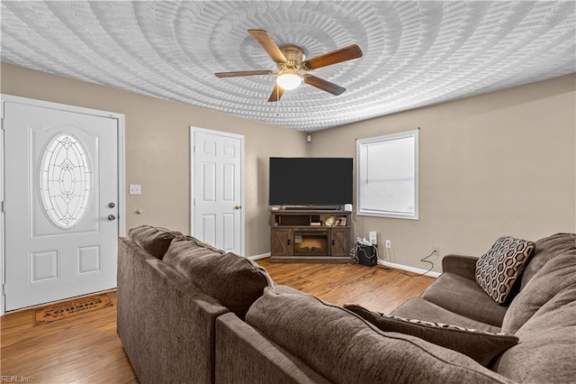 living room featuring ceiling fan, a healthy amount of sunlight, and light wood-type flooring